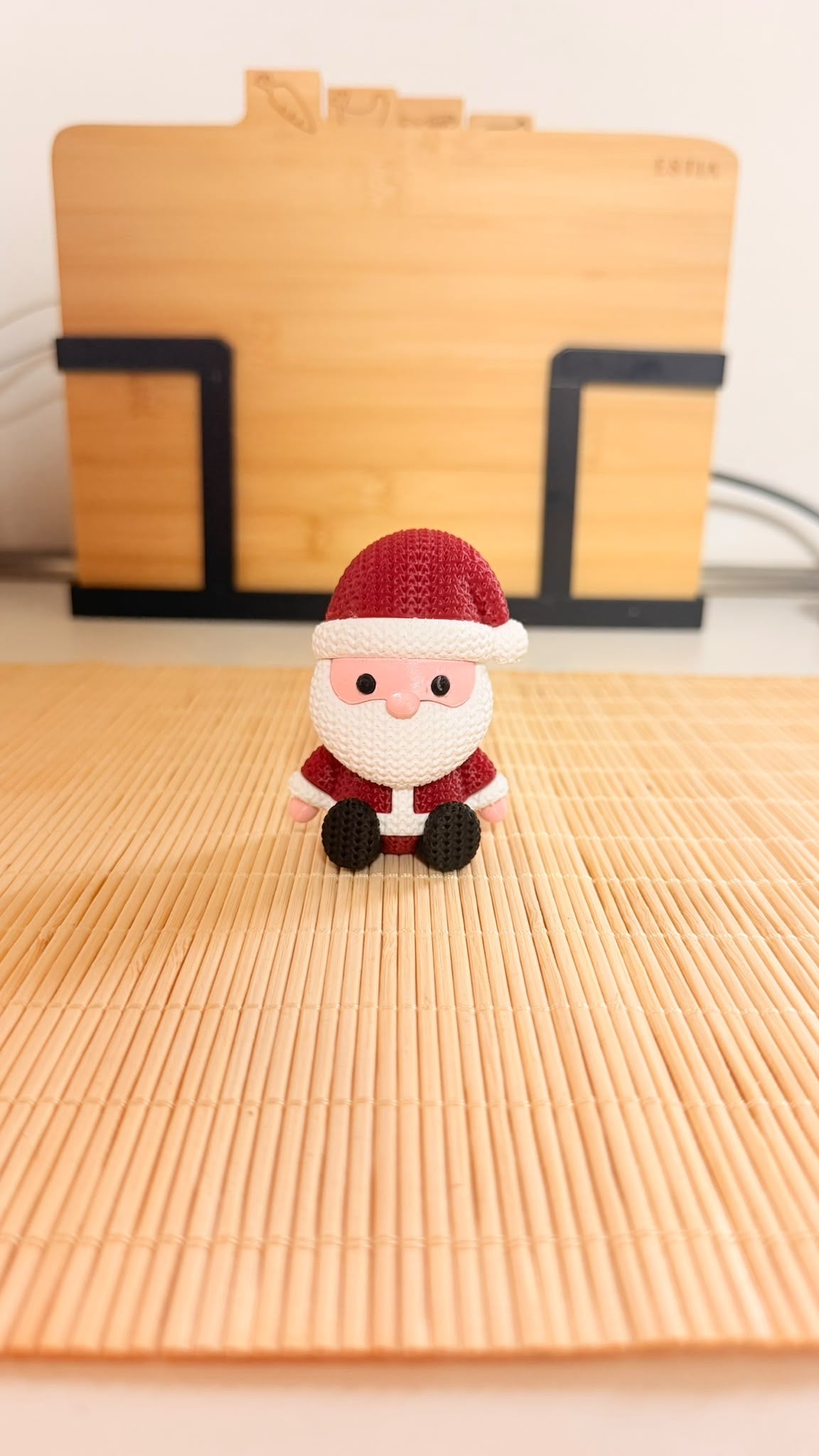 Babbo Natale decorativo seduto con cappello e abito rossi effetto maglia, barba bianca e scarpette nere